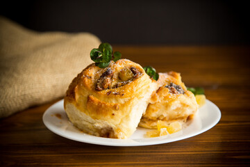 Sweet curled bun with jam, raisins in powdered sugar