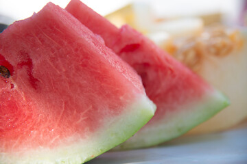 Red pieces of watermelon on melon background close-up. Selective focus.The concept of healthy vitamin fruits