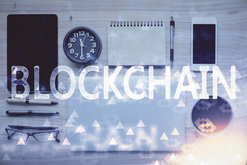 Double exposure of blockchain theme hologram over table with phone. Top view. Crypto technology...