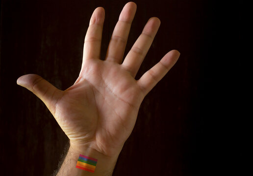 Man's hand with the colors of the gay flag. 3D rendering or 3D illustration.