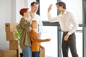 family giving high five to professional realtor or agent closing deal, satisfied family handshaking...