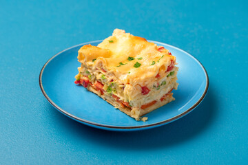Vegetarian lasagna on a blue plate. Single portion of lasagna