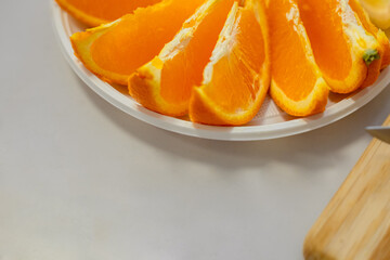 Closeup oranges slices on a table. Fruit appetizer.  Ripe fresh fruit pieces on plate. Copy space for text. 
