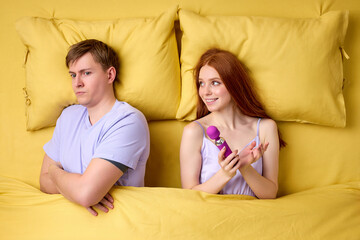 Young impotent man worried on bed. couple having problems in bedroom. wife need more sex