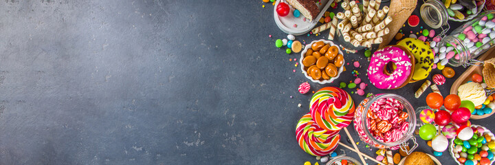 Selection of colorful sweets. Set of various candies, chocolates, donuts, cookies, lollipops, ice cream top view on black concrete background