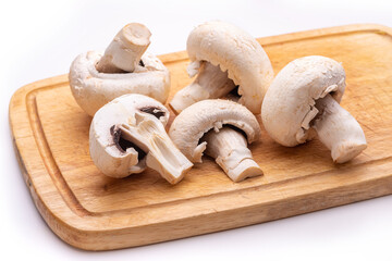 White champignons on a wooden cutting board