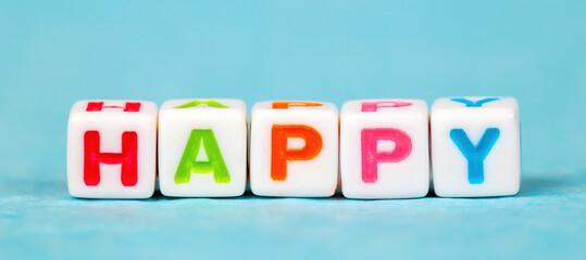 Happy, happiness concept, cubes with colorful letters on blue background