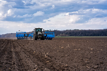 Fototapeta premium sowing campaign in the field in early spring. Tractor with seeder