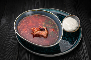 Ukrainian borsch on a dark wooden table
