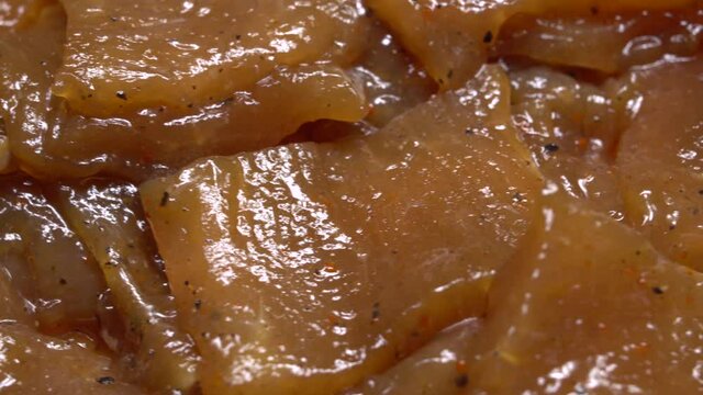 Thinly cut, skinless raw chicken meat ready for a stir-fry. Uncooked, marinated in soy sauce and spices.
Chinese food. Close up. Food background.
Rotation.