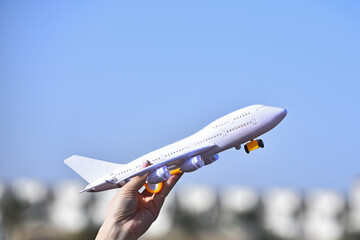 White airliner toy model in female hand. Airplane. Dream flying to trip.