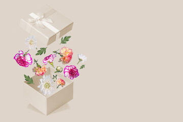 Luxurious Gift box with flying colorful flowers and leaves on a trendy colored background. Minimal spring or summer concept.
