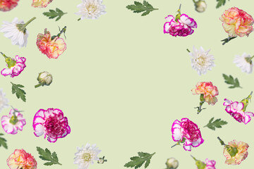 Spring or summer layout with many different  colorful flying flowers and leaves on a light green background, trendy floral frame.