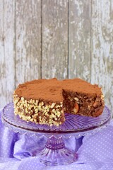 Vegan raw chocolate cake with dates, almond nuts, mashed banana and cacao powder on cake stand