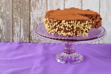 Vegan raw chocolate cake with dates, almond nuts, mashed banana and cacao powder on cake stand