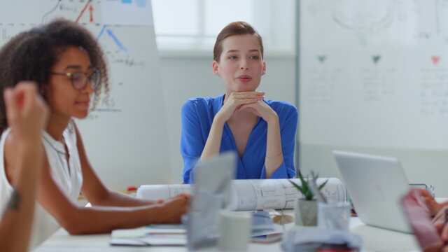 Business woman talking employees office. Female boss sitting table colleagues