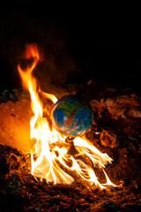 Fire takes an earth globe on cement shapes of abandoned building. Modern concept photo.