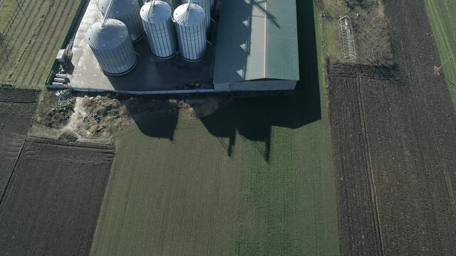 Grain silos storage. Aerial Drone Shot flying over. Aerial drone shot of stainless silos for storing crops. Top down view.