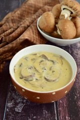 Cream of mushroom soup in a bowl on wooden background