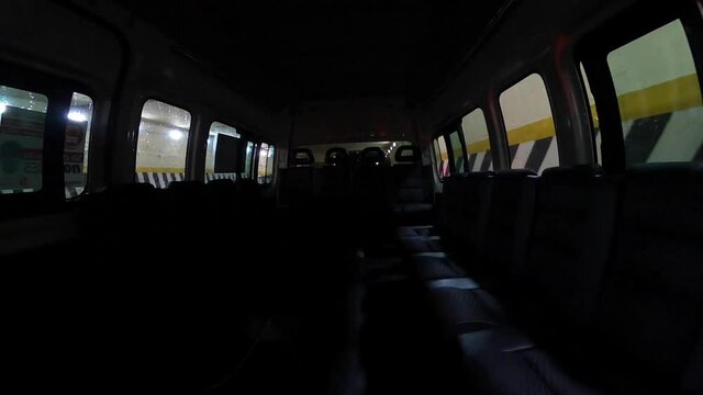 Interior de vagoneta de transporte p&uacute;blico vac&iacute;a sale de t&uacute;nel y avanza por avenida