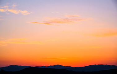Fototapeta na wymiar Sunset in the mountains. Layered mountains. Haze at sunset.