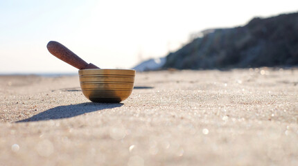 Himalayan tibetian singing bowl on sand natural background. Harmony and relaxation concept, with...
