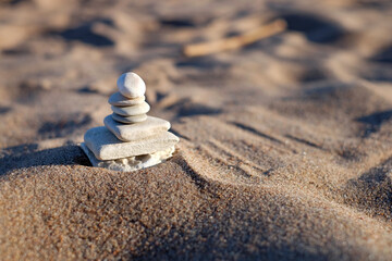 Fototapeta na wymiar Balance pyramid stones on sand. Copy space