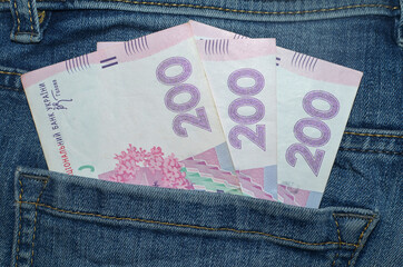  200 hryvnia bills (UAH) in the back pocket of blue jeans. Money concept