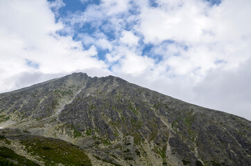 Obraz na płótnie Canvas Beautiful sharp mountain peaks in summer time in National Park High Tatras with cloudy sky.