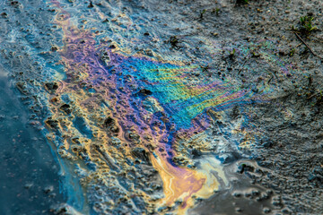 Spill of oil products. Rainbow oily streaks on polluted land and water