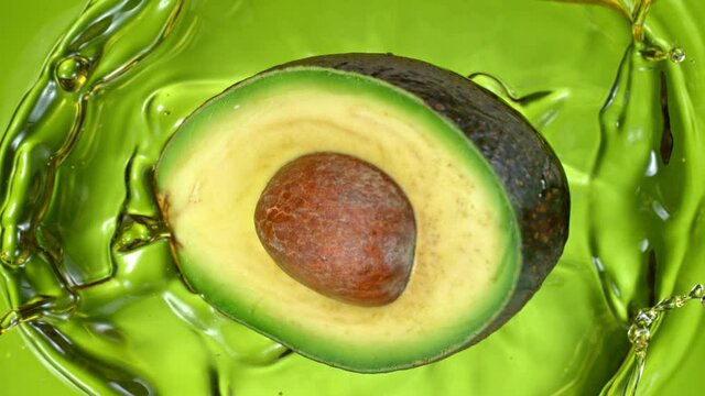 Super Slow Motion Shot of Fresh Avocado Falling and Splashing into Oil at 1000 fps.