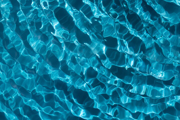 Sun glare in the transparent blue water.  Blue water wave texture background.