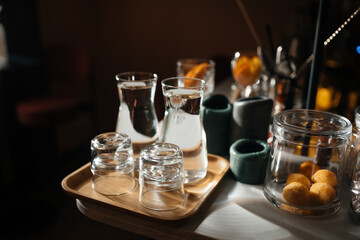 Four glass cups on the bar counter with serving accessories.