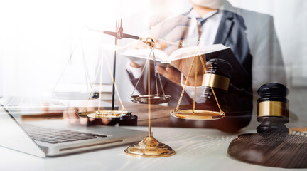 Justice and law concept.Male judge in a courtroom with the gavel, working with, computer and docking keyboard, eyeglasses, on table in morning light