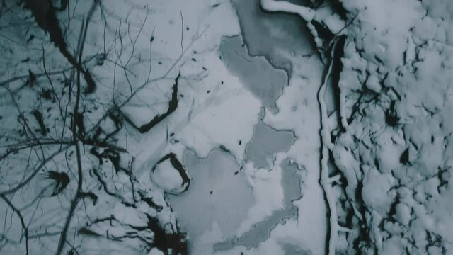 Frozen river in dimly lit forest (two shots)
