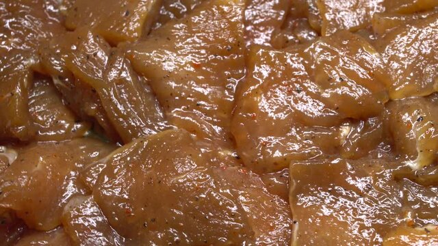 Thinly cut, skinless raw chicken meat ready for a stir-fry. Uncooked, marinated in soy sauce and spices.
Chinese food. Close up. Food background.
Rotation.