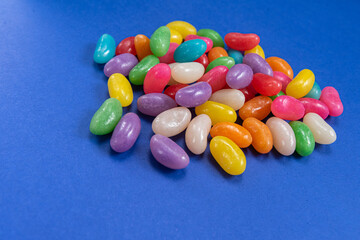 Several Jelly Beans over blue background.