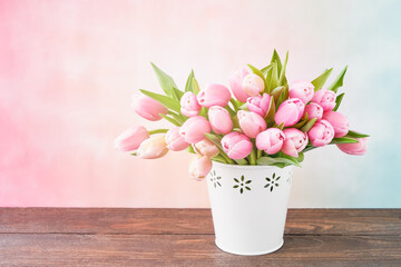 Pink tulips bouquet in a white vase on a pink background. Valentine Day, Mothers day, birthday celebration concept.