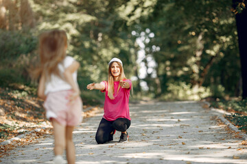 Mother with daughter playing in a summer park