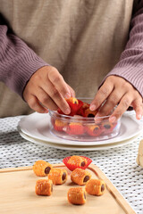 Asian Female Hand Put  Kue Kering (Cookies) on the Clear Box, Preparation for Sale Ied Mubarak Kue Lebaran. Arrange Ied Cookie on the Box. Mengatur Kue Lebaran di Toples