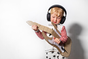 child with acoustic string instrument. girl playing guitar. musical instrument handmade of...