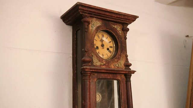 Broken antique mechanical wall clock that once showed the hour in room. Time