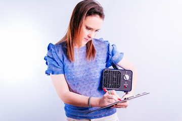 Young beautiful woman in charge of cleaning company holding an ozone generating machine writing orders . disinfection concept on white background. covid 19. professional industrial equipment