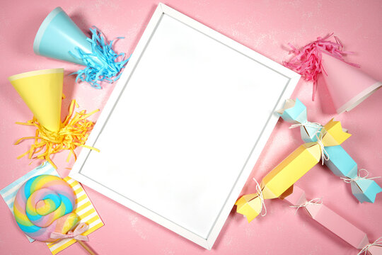 Artwork print frame. Birthday and parties theme SVG craft product flat lay mock up styled stock photo. Styled with pink, blue and yellow party hats and bon bons on a textured pink background.