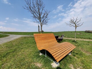 Luxuriöse Sonnenliege im Frühling oder Sommer bei Sonne, blauem Himmel und weißen Wolken an...