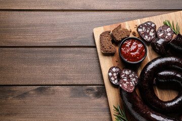 Fototapeta na wymiar Tasty blood sausages served on wooden table, top view. Space for text