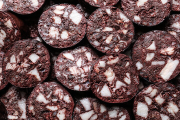 Slices of tasty blood sausage as background, top view