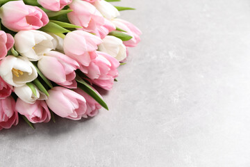 Beautiful bouquet of tulips on light table. Space for text