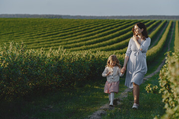 Fototapeta premium Pregnant mother with her daughter in a field
