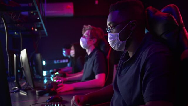 A difficult training day at the cyber team bootcamp is over, the masked gamers take off their headphones, get up from the table and leave
